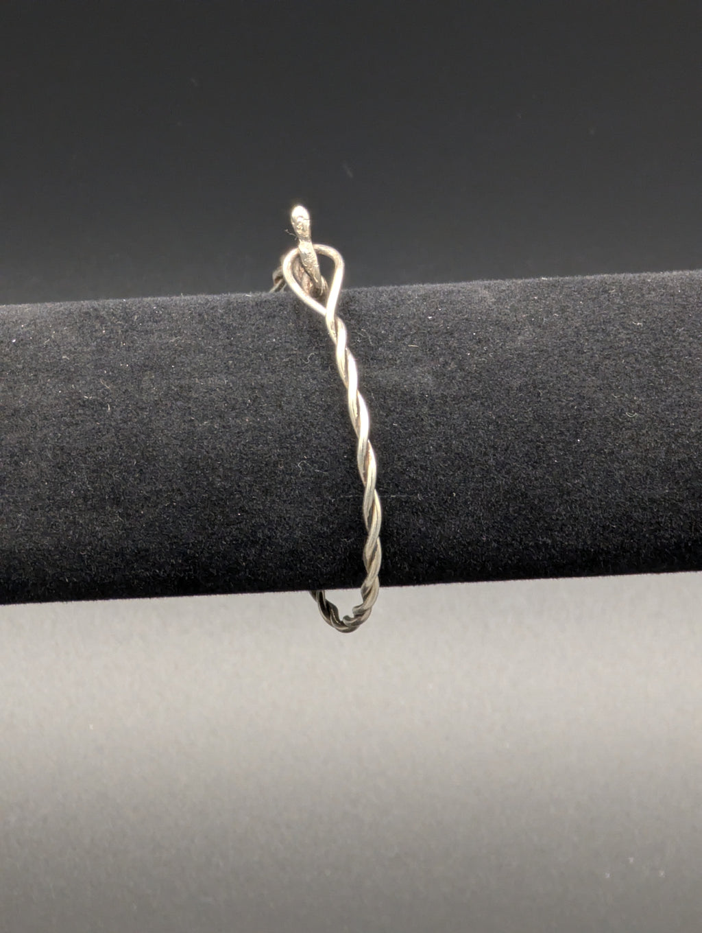 Silver bracelet consisting of a thin wire twisted and doubled back on itself as a simple latch.