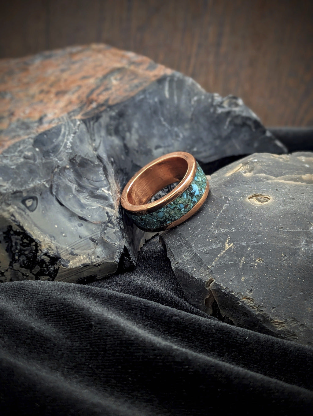 Heavy copper ring with turquoise inlay design on a textured surface